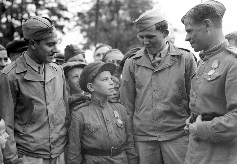 Американці в Полтаві, 1944 рік. Сержант Вайншенкер і технік-сержант Топпс поряд із сином полку 169-ї авіабази особливого призначення під Полтавою. Його ім’я невідоме, мав 10 років, служив помічником техніка з озброєння